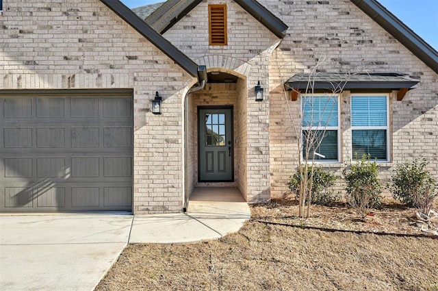 property entrance with a garage and brick siding