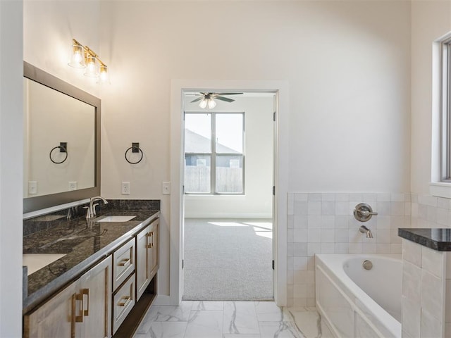 bathroom with ceiling fan, a tub, and vanity