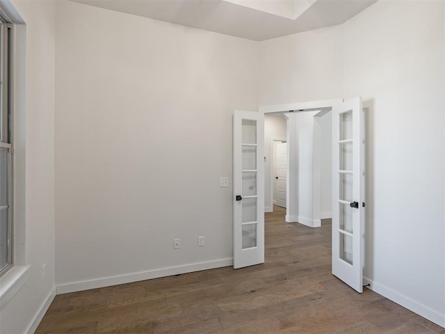 spare room featuring hardwood / wood-style floors and french doors