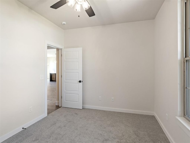 spare room featuring ceiling fan and light colored carpet