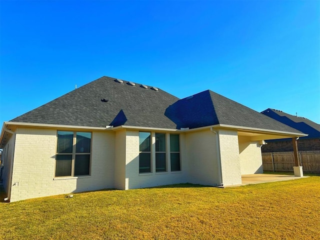 rear view of property featuring a patio area and a lawn