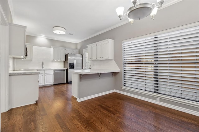 kitchen featuring white cabinetry, dark wood-type flooring, stainless steel appliances, kitchen peninsula, and ornamental molding