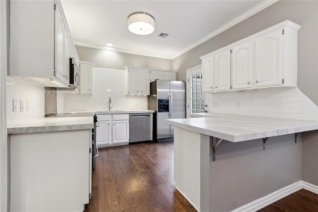 kitchen featuring white cabinetry, sink, dark hardwood / wood-style floors, kitchen peninsula, and appliances with stainless steel finishes