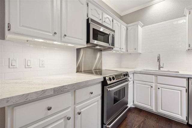 kitchen with white cabinets, crown molding, sink, appliances with stainless steel finishes, and dark hardwood / wood-style flooring