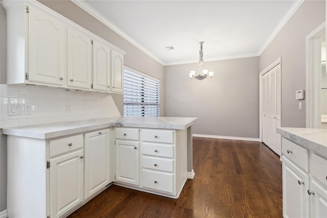 kitchen with white cabinetry, hanging light fixtures, dark hardwood / wood-style floors, and ornamental molding