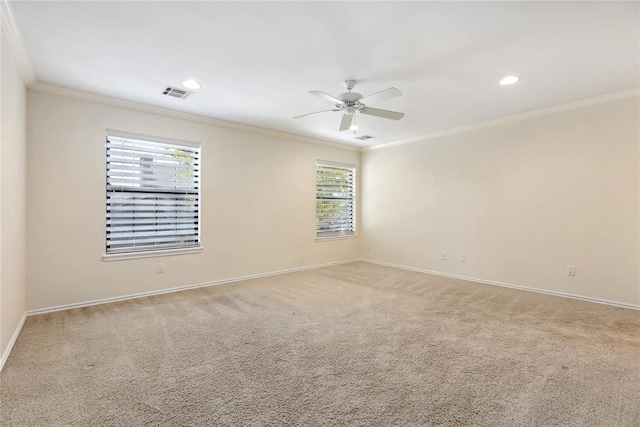 carpeted spare room featuring ceiling fan and crown molding