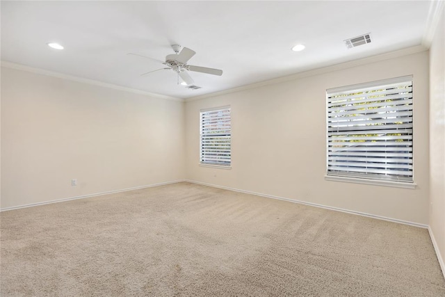 unfurnished room featuring light carpet, a wealth of natural light, and crown molding