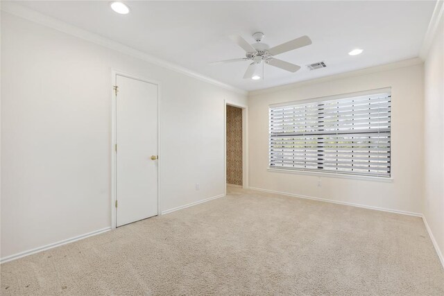 unfurnished room with light carpet, ceiling fan, and crown molding