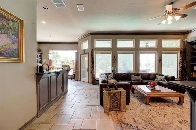 living room featuring crown molding, ceiling fan, and a healthy amount of sunlight