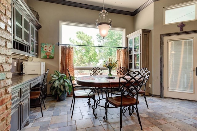 dining area featuring a healthy amount of sunlight and crown molding