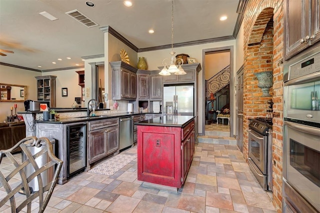 kitchen featuring sink, stainless steel appliances, wine cooler, kitchen peninsula, and decorative light fixtures