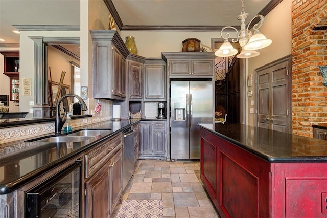 kitchen with a center island, an inviting chandelier, sink, appliances with stainless steel finishes, and decorative light fixtures