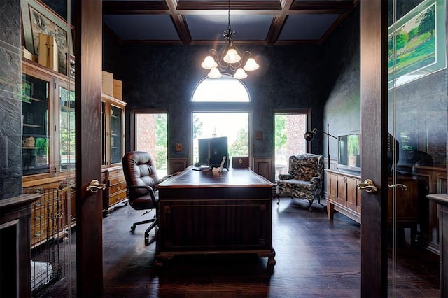 home office with a towering ceiling, coffered ceiling, beam ceiling, a chandelier, and dark hardwood / wood-style floors