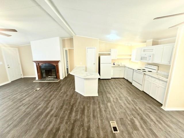 kitchen with ceiling fan, a kitchen island, dark hardwood / wood-style floors, white appliances, and white cabinets