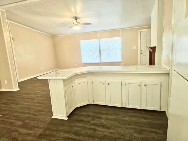 kitchen featuring ceiling fan, white cabinetry, dark hardwood / wood-style flooring, and kitchen peninsula