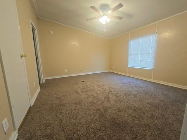 unfurnished room featuring dark colored carpet, ceiling fan, and crown molding