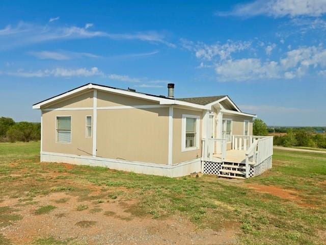 back of property featuring a yard and a deck