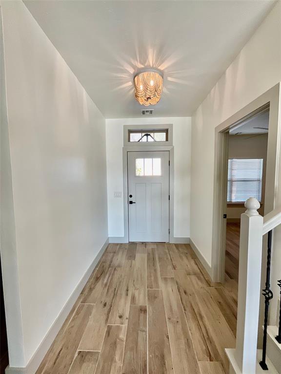 entryway with light hardwood / wood-style flooring and a chandelier