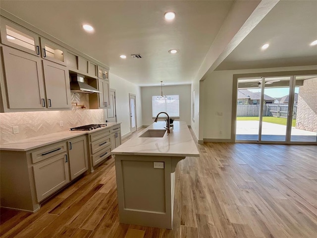 kitchen with sink, an island with sink, and wood-type flooring