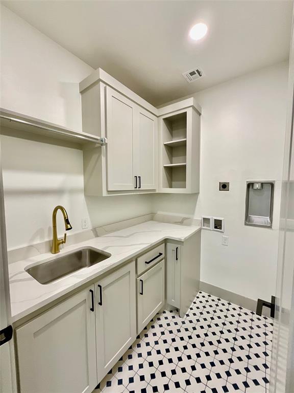 laundry area with washer hookup, electric dryer hookup, cabinets, and sink