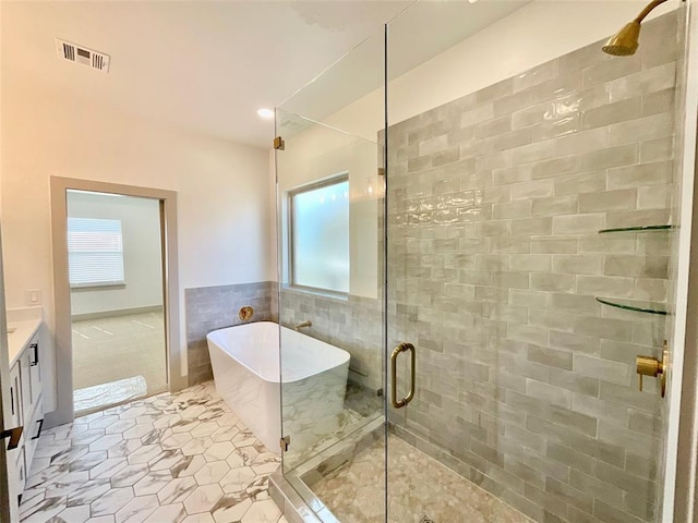 bathroom featuring separate shower and tub, a wealth of natural light, vanity, and tile walls