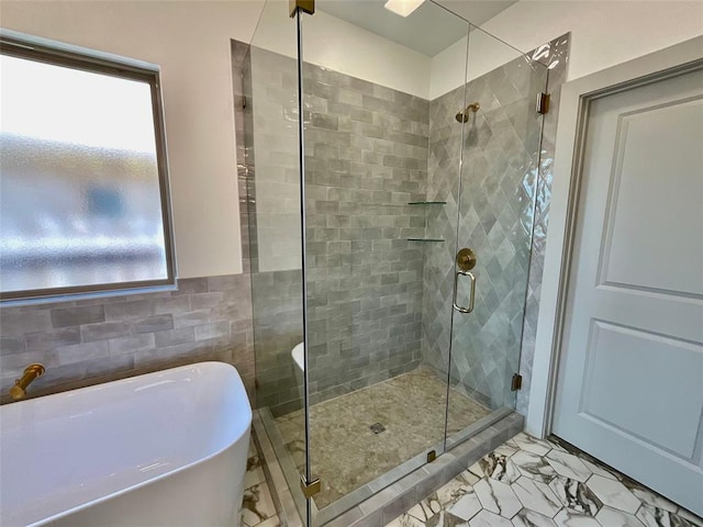 bathroom featuring tile walls and independent shower and bath