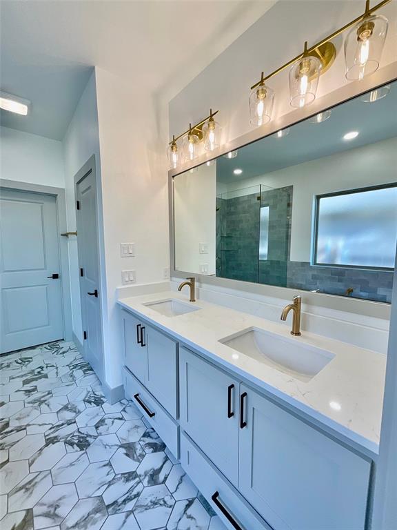 bathroom featuring vanity and tiled shower