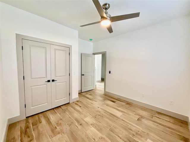 unfurnished bedroom with ceiling fan, a closet, and light hardwood / wood-style flooring