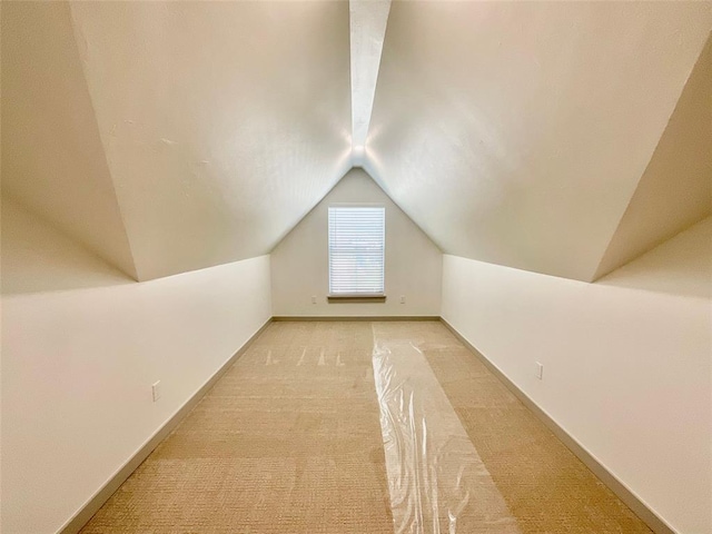 bonus room featuring light colored carpet and vaulted ceiling