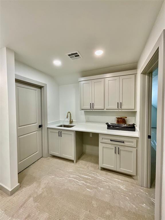 interior space featuring light colored carpet and sink