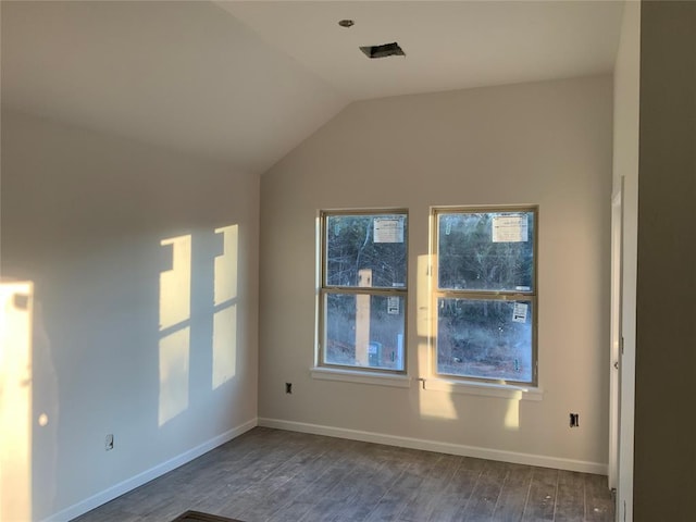 spare room featuring dark hardwood / wood-style flooring and lofted ceiling