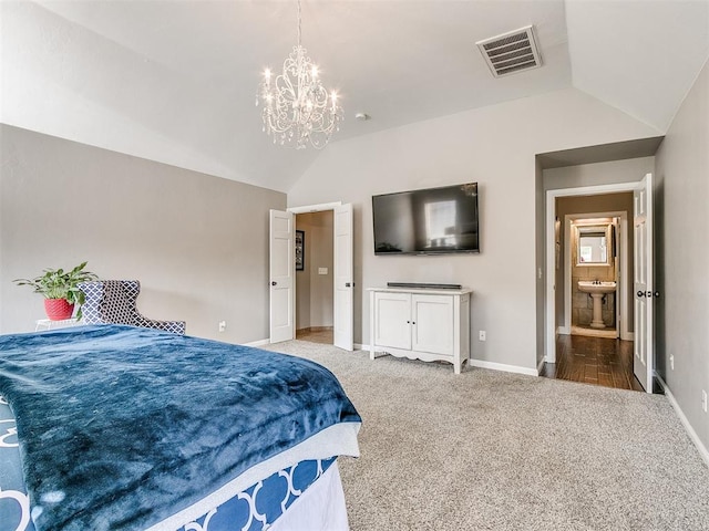 carpeted bedroom with ensuite bathroom, vaulted ceiling, and a notable chandelier