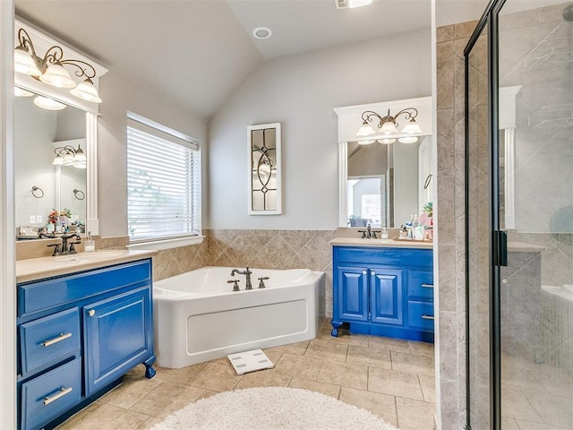 bathroom with tile patterned flooring, vanity, independent shower and bath, and lofted ceiling