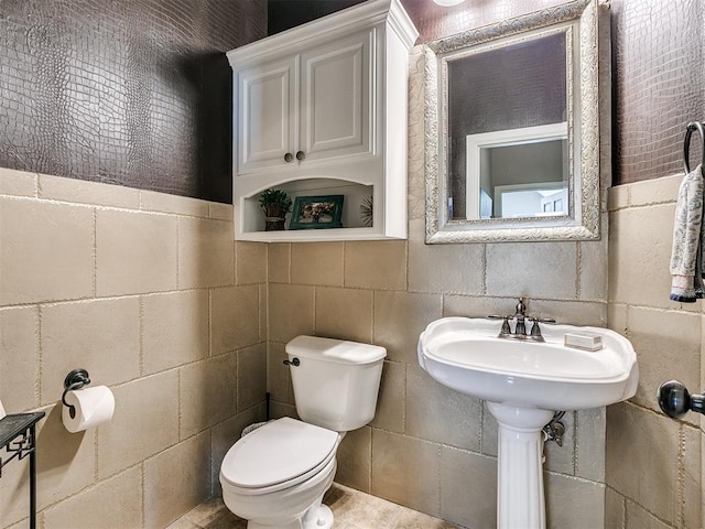 bathroom featuring tile patterned flooring, tile walls, and toilet