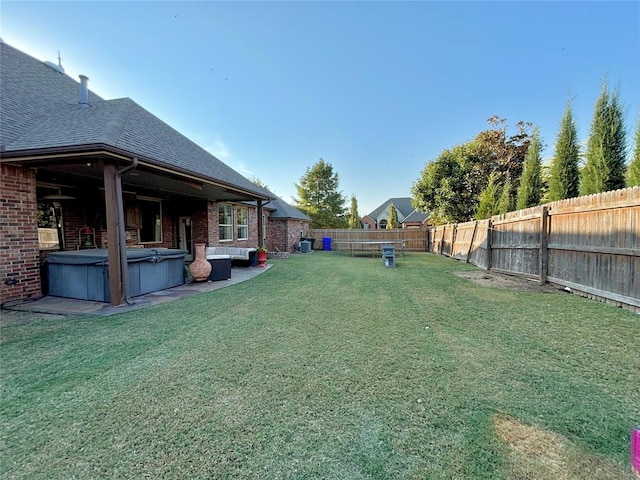 view of yard with a hot tub and a patio area