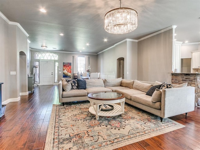 living room featuring dark hardwood / wood-style floors, an inviting chandelier, and crown molding