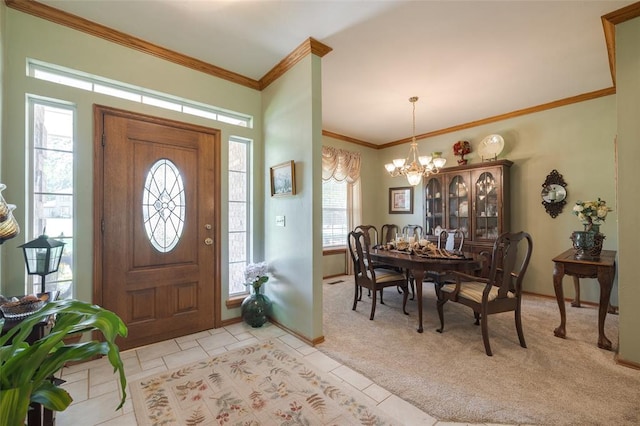 foyer entrance with crown molding, light colored carpet, and an inviting chandelier