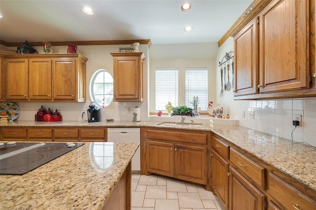 kitchen with sink, tasteful backsplash, light stone counters, white dishwasher, and black electric stovetop