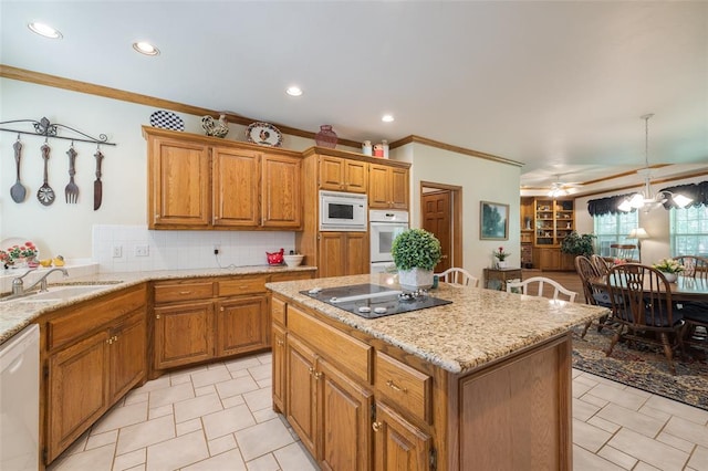 kitchen with white appliances, crown molding, sink, an inviting chandelier, and a kitchen island