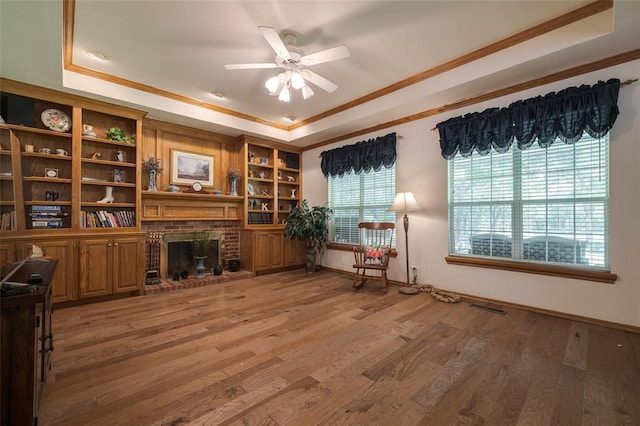 unfurnished office featuring a raised ceiling, crown molding, and hardwood / wood-style flooring