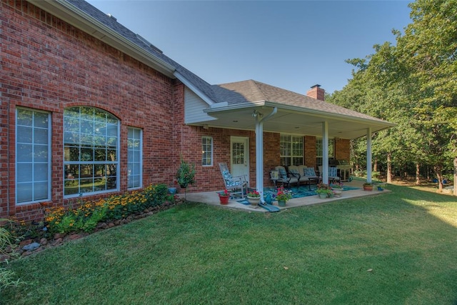 back of house with a patio and a lawn