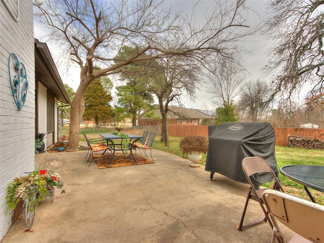 view of patio featuring area for grilling, outdoor dining area, and fence