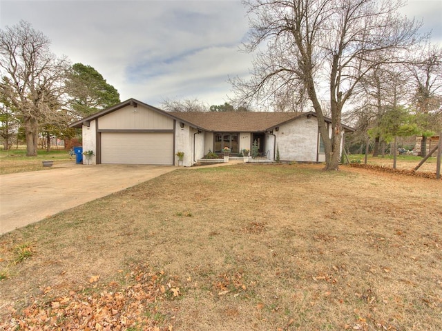 view of front of house with an attached garage, concrete driveway, and a front yard