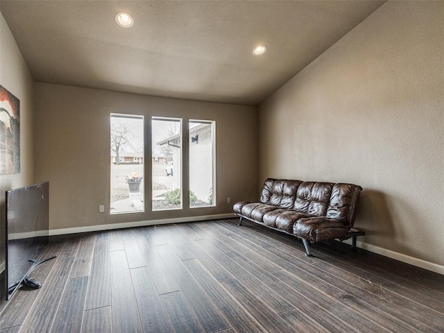 living area with dark wood-type flooring and baseboards