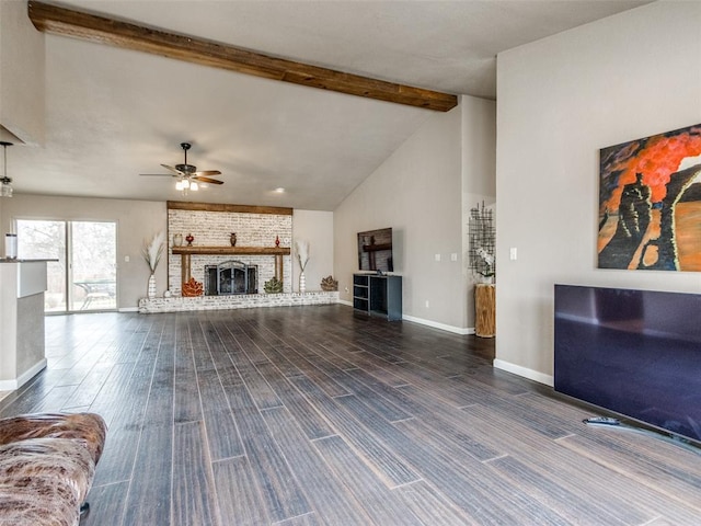 living room featuring a ceiling fan, a brick fireplace, beamed ceiling, and wood finished floors