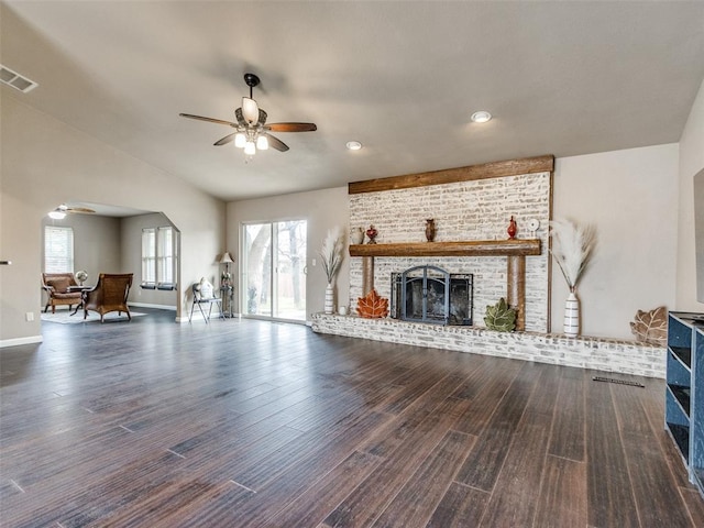 unfurnished living room with wood finished floors, a ceiling fan, visible vents, baseboards, and a fireplace