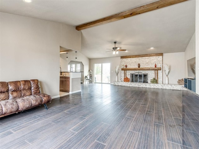 unfurnished living room with a brick fireplace, lofted ceiling with beams, ceiling fan, and wood finished floors