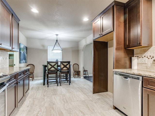 kitchen with light stone counters, backsplash, appliances with stainless steel finishes, and arched walkways