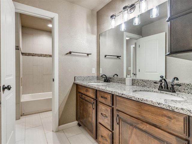 full bathroom with tile patterned flooring, double vanity, baseboards, and a sink