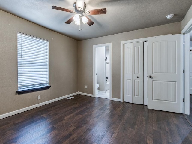 unfurnished bedroom with connected bathroom, a closet, baseboards, and wood finished floors